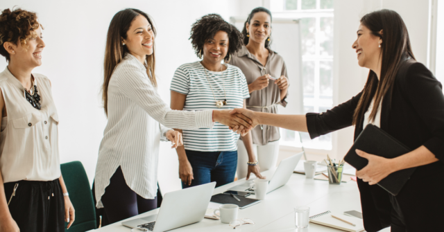 group of cowokers in office welcoming new hire temp to hire candidate